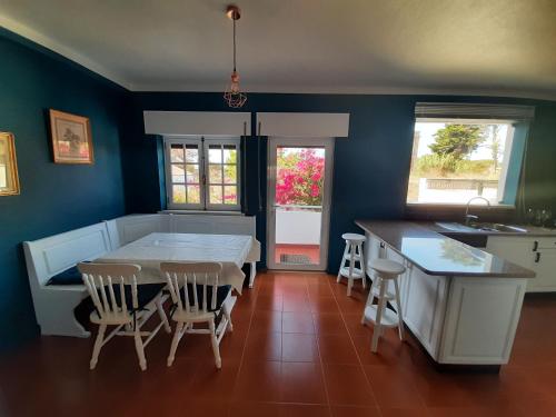 a kitchen and dining room with a table and chairs at Parfum de la Mer in Sines