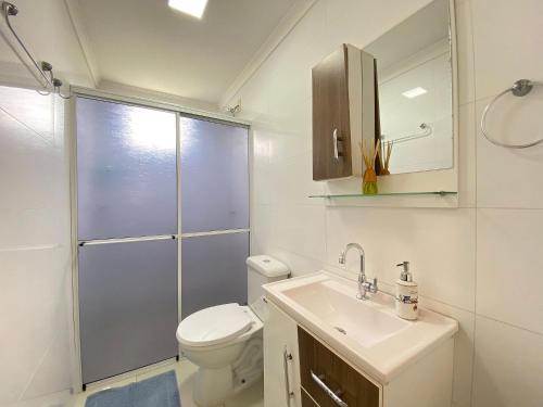 een badkamer met een toilet, een wastafel en een douche bij Aconchegante Apartamento na Praia de Bombas com ótima localização. in Bombinhas