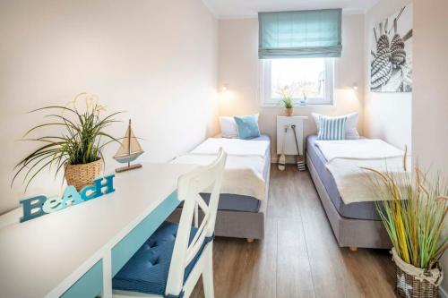 um quarto com 2 camas e uma secretária com plantas em Dream BIg Strandsuite em Rettin