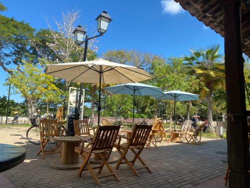 un patio al aire libre con mesas, sillas y sombrillas en Casa Portales de Santa Bárbara en Mompox