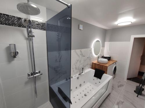 uma casa de banho com um chuveiro, uma banheira e um lavatório. em Groom Epernay - Jacuzzi & Champagne em Épernay