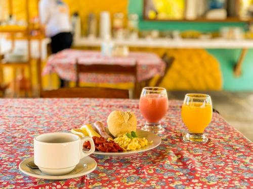 a table with a plate of food and two glasses of orange juice at Pousada Theodora in Macapá