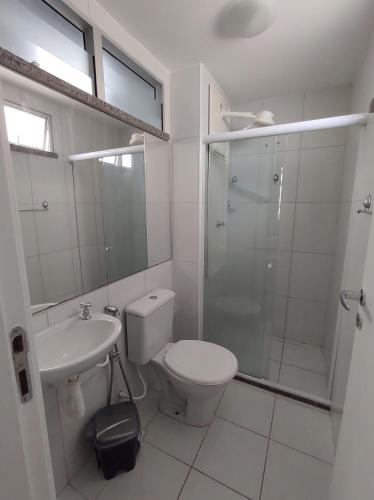 a bathroom with a toilet and a shower and a sink at Apartamento Condominio Caminho dos Ventos in Aracaju
