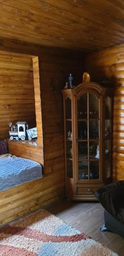 Dormitorio en cabaña de madera con cama y armario en Cazare la Kataleya en Sighişoara