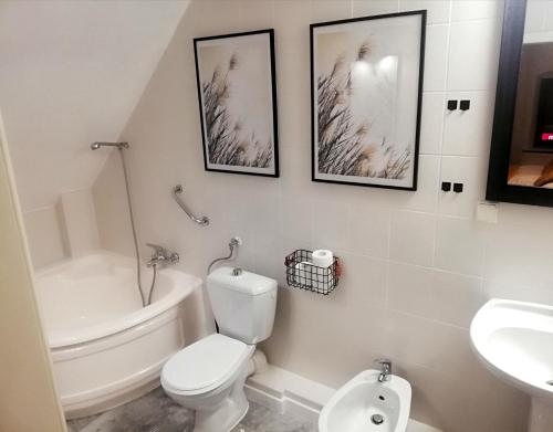 biała łazienka z toaletą i umywalką w obiekcie Great Polonia Jelenia Góra City Center w Jeleniej Górze
