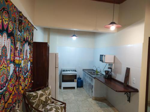 a kitchen with a refrigerator and a counter in a room at Casa de Praia Picinguaba in Ubatuba