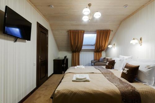 a hotel room with two beds and a flat screen tv at GasthauS & SPA in Bukovel