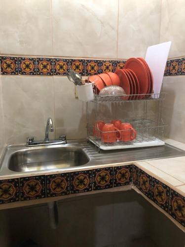 a kitchen sink with a plate rack next to it at La Capelina Apartment in ExHacienda la Escalera in Guanajuato
