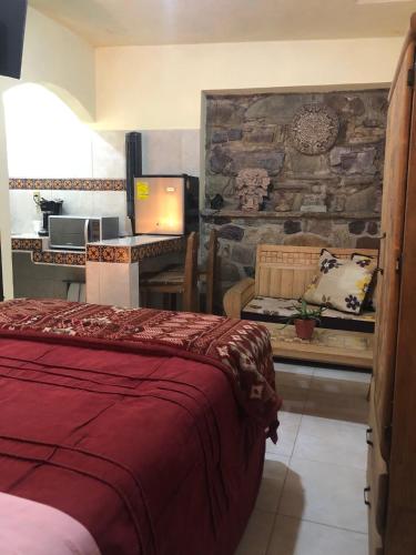a bedroom with a bed and a desk with a computer at La Capelina Apartment in ExHacienda la Escalera in Guanajuato