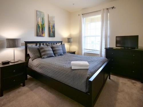 ein Schlafzimmer mit einem großen Bett und einem TV in der Unterkunft 3Br 2Bath Condo Balcony 5min Conv Center 1388ft in Orlando