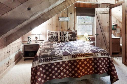 a bedroom with a large bed with a wooden wall at Misty View Cabin in Hatchertown