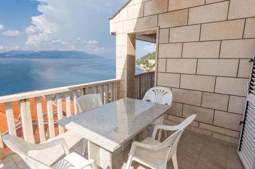 a table and chairs on a balcony with a view of the water at Holiday Home in Komarna