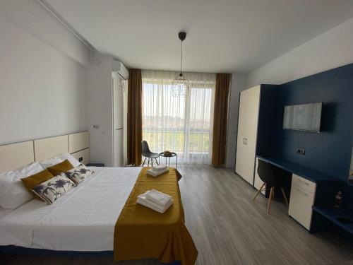 1 dormitorio con 1 cama grande y TV en Summer breeze Studio - Onix Blue Mamaia Nord, en Mamaia Nord – Năvodari
