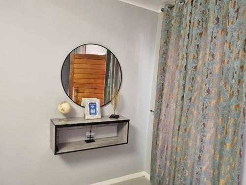 a mirror on a wall next to a shower curtain at Villa 13 Maun in Maun