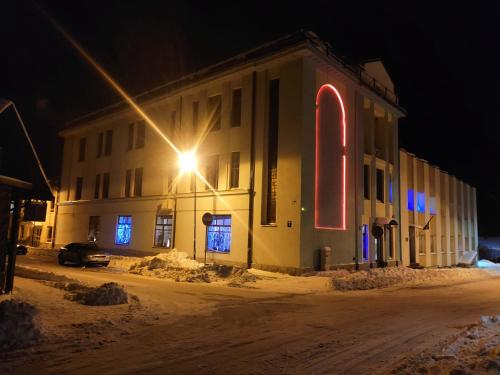 een gebouw met een straatlicht in de sneeuw 's nachts bij Hotel Ludza in Ludza