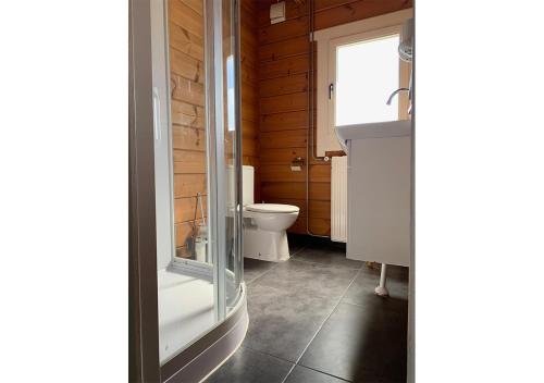La salle de bains est pourvue d'une douche, de toilettes et d'un lavabo. dans l'établissement Chaletparc Krabbenkreek Zeeland - Chalet 214, à Sint-Annaland