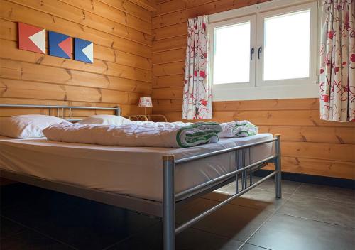 Ce lit se trouve dans une chambre en bois dotée d'une fenêtre. dans l'établissement Chaletparc Krabbenkreek Zeeland - Chalet 214, à Sint-Annaland