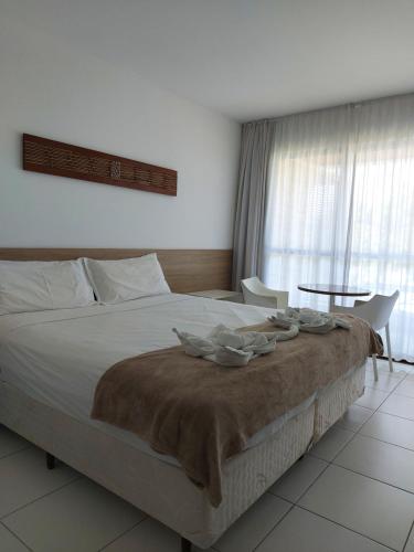 a bedroom with a large bed and a table at Iloa Prime 103 V in Barra de São Miguel