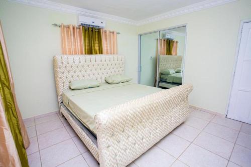 a bedroom with a bed and a wicker chair at Villas Garcia in Las Terrenas