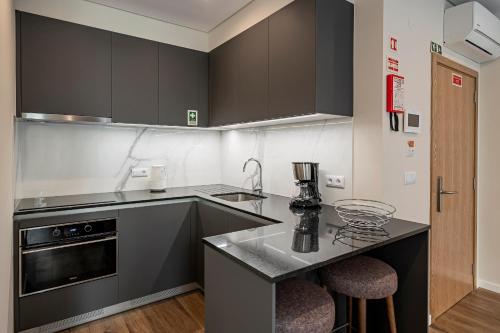 a kitchen with black cabinets and a counter top at Monumental Plaza by Petit Hotels in Funchal