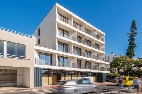 a building on a street with cars driving past it at Monumental Plaza by Petit Hotels in Funchal