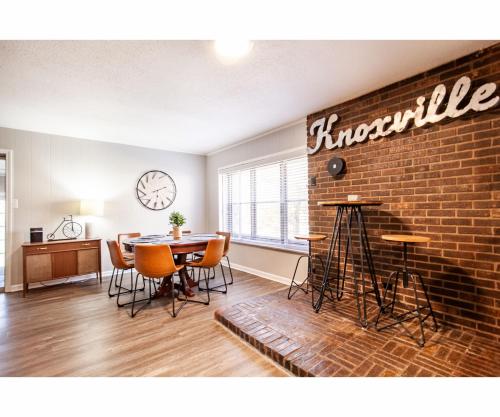 a dining room with a table and a brick wall at Classic Lake House Lakefront with Fire Pit and Dock in Louisville