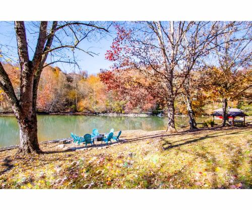 a painting of a park with two chairs and a lake at Classic Lake House Lakefront with Fire Pit and Dock in Louisville