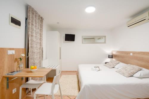 sypialnia z łóżkiem, stołem i biurkiem w obiekcie Apartments & Rooms Buble w Trogirze