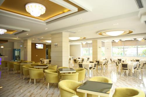 un ristorante con tavoli e sedie in una stanza di Hotel Pogradeci a Pogradec