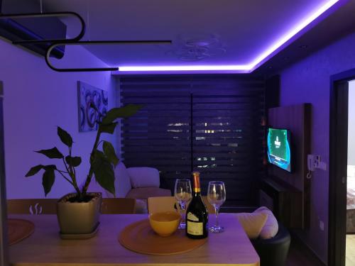 a purple room with a table with two wine glasses at Avenija in Kragujevac