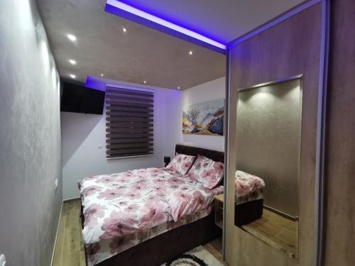 a bedroom with a bed with a purple ceiling at Avenija in Kragujevac