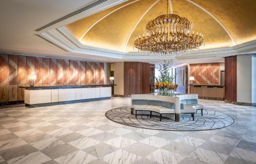 a lobby with a chandelier and a table and chairs at Cordis, Auckland by Langham Hospitality Group in Auckland