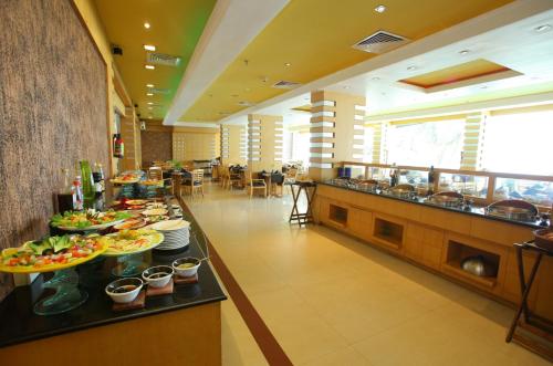 a buffet line with plates of food in a restaurant at The Quilon Beach Hotel and Convention Center in Kollam