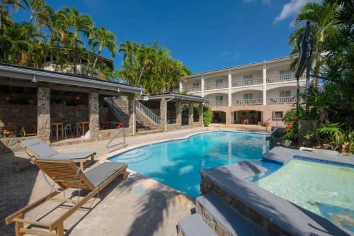 Lazy Parrot Inn & Mini Resort في رينكون: فندق فيه مسبح ومنتجع