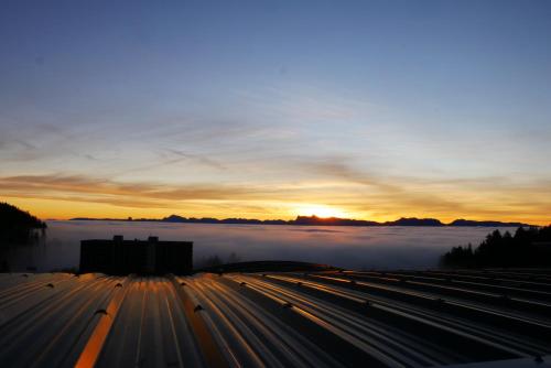 a view of a city with the sun rising above the clouds at Appartement 4 personnes 32m2 Au pied des pistes- WiFI- Balcon Sud- Chamrousse 1650 in Chamrousse