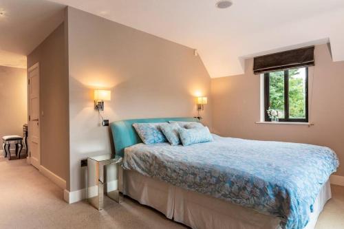 a bedroom with a bed with blue sheets and a window at Luxury Country House on the Hill in Kenmare