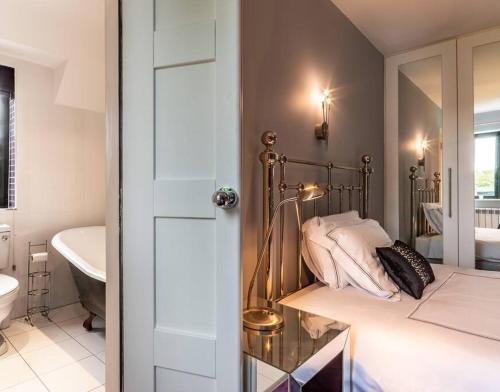 a bedroom with a bed and a sink and a mirror at Luxury Country House on the Hill in Kenmare