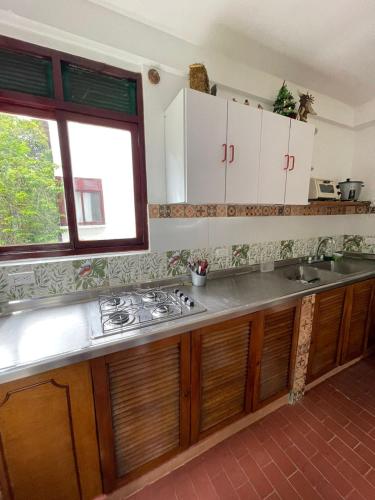 a kitchen with a stove and a sink and a window at Hostería tropical la florida in La Florida