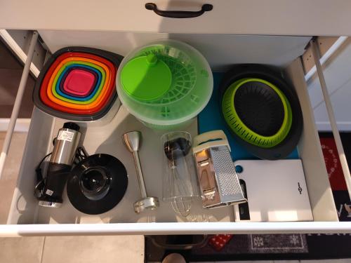 a drawer filled with dishes and other kitchen utensils at Petite maison alsacienne in Entzheim
