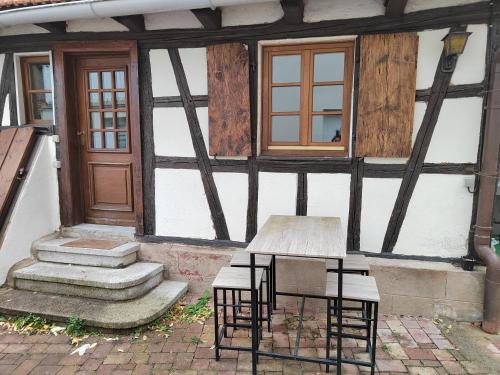 a table and chairs in front of a building at Petite maison alsacienne in Entzheim