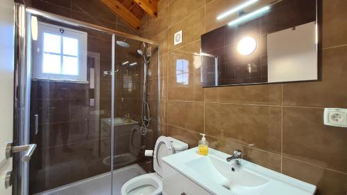 een badkamer met een toilet, een wastafel en een douche bij Villa da Silva in Madalena