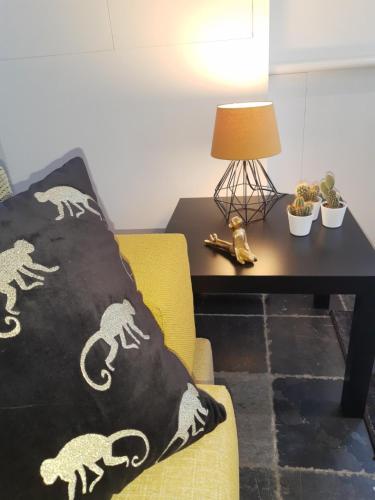a living room with a yellow chair and a table with a pillow at Vakantiewoning 'De Vlaamse Aap' in Dilsen-Stokkem
