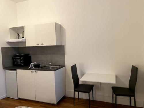 - une cuisine avec 2 chaises, un évier et une table dans l'établissement La Tournette, à Annecy