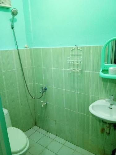a bathroom with a shower and a toilet and a sink at BM Island Inn in Bantayan Island