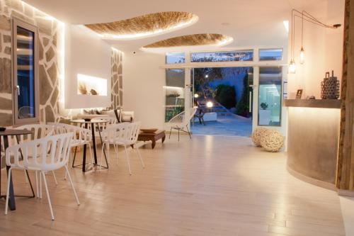 a living room with white chairs and a table at Malibu Boutique Studios & Bungalows in Faliraki