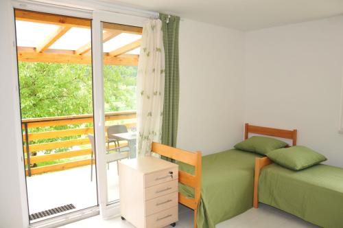 a bedroom with a bed and a balcony at Apartment Tina in Bohinj