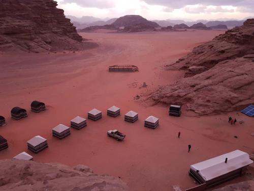 an aerial view of a desert with a group of trailers at um sabatah Camp in Wadi Rum