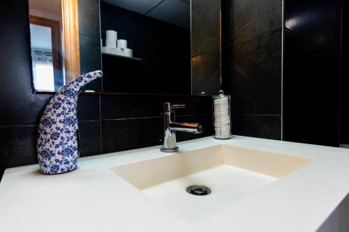 Un lavabo de baño con un jarrón encima. en Dreams Almería Center, en Almería
