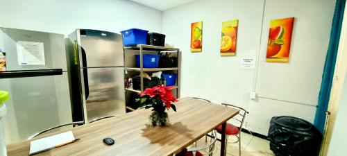 a kitchen with a table with a vase of flowers on it at HOM Centro histórico in Mexico City