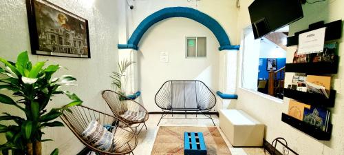 a room with two chairs and a table and a plant at HOM Centro histórico in Mexico City